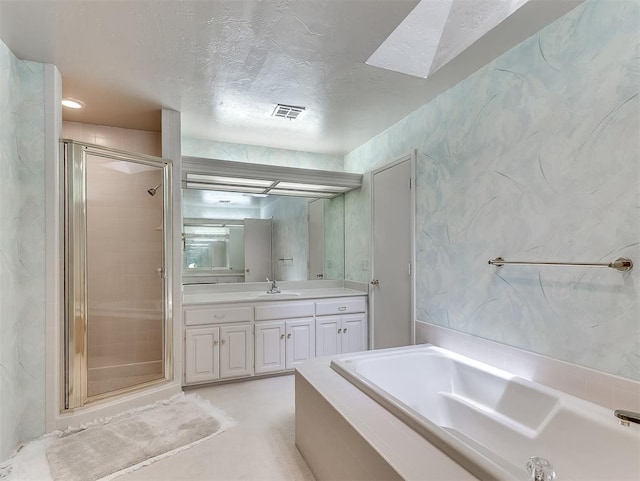 13504 Fox Creek Dr, Oklahoma City, OK 73131 - bathroom featuring a garden tub, a stall shower, vanity, a textured ceiling, and a skylight