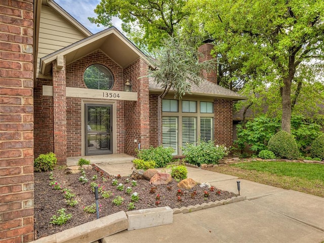 13504 Fox Creek Dr, Oklahoma City, OK 73131 - doorway to property with brick siding, a chimney, and roof with shingles
