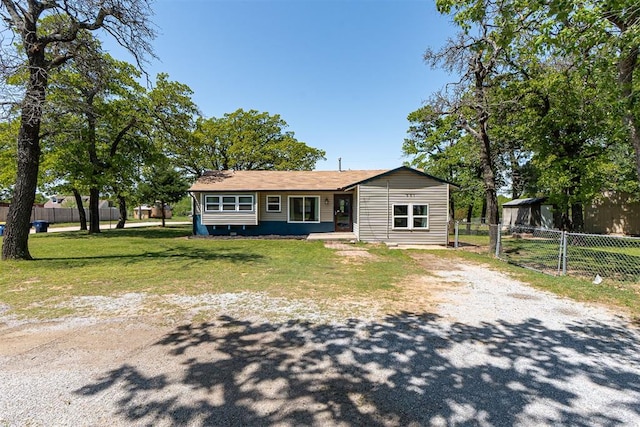 ranch-style home featuring fence, driveway, and a front yard