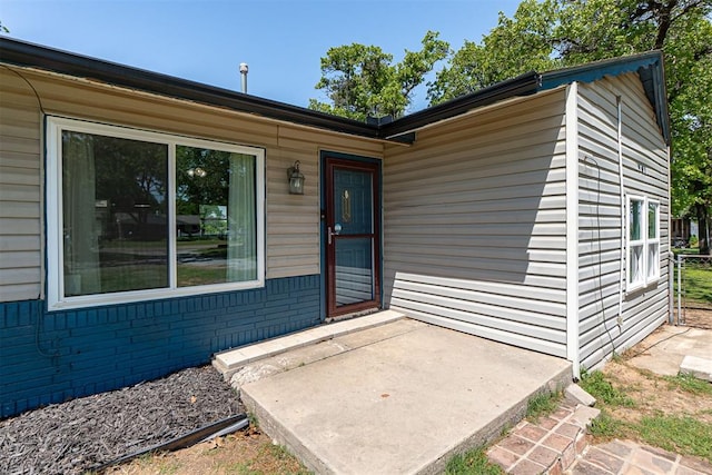 view of exterior entry with a patio
