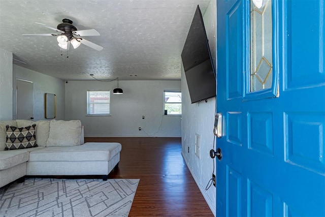 entrance foyer with a ceiling fan, a textured ceiling, and dark wood finished floors