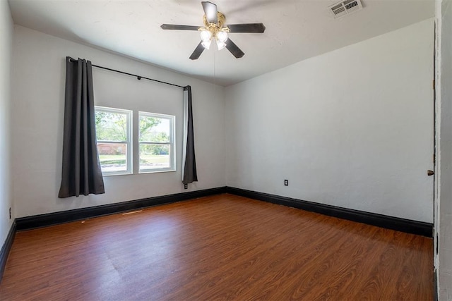 spare room featuring ceiling fan, baseboards, wood finished floors, and visible vents