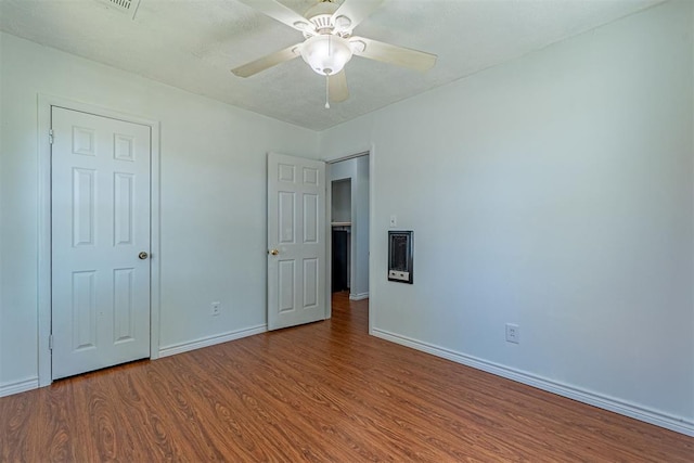 unfurnished bedroom featuring wood finished floors, baseboards, and ceiling fan