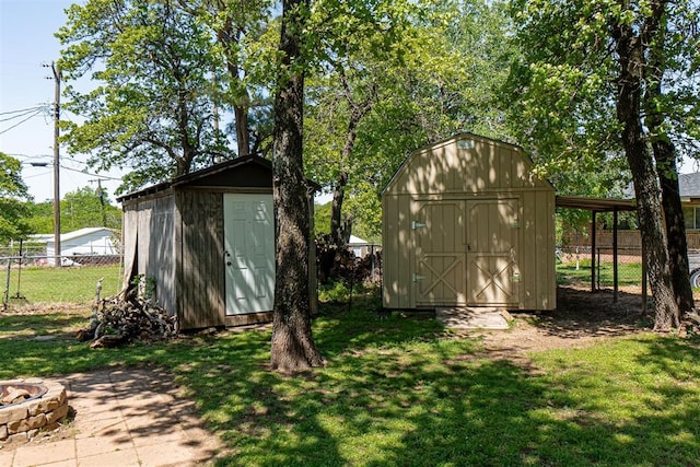 view of shed featuring fence and an outdoor fire pit