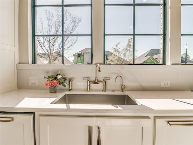 6105 NW 147th Ter, Oklahoma City, OK 73142 - kitchen featuring a sink, light countertops, and white cabinetry