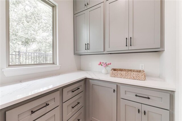 6105 NW 147th Ter, Oklahoma City, OK 73142 - interior space featuring a wealth of natural light, gray cabinetry, and light stone countertops