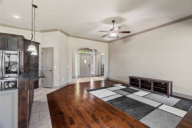 2828 Ryder Dr, Yukon, OK 73099 - foyer entrance with crown molding, baseboards, ceiling fan, light wood-type flooring, and arched walkways