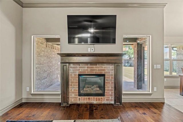 2828 Ryder Dr, Yukon, OK 73099 - unfurnished living room featuring crown molding, baseboards, a fireplace, and hardwood / wood-style floors