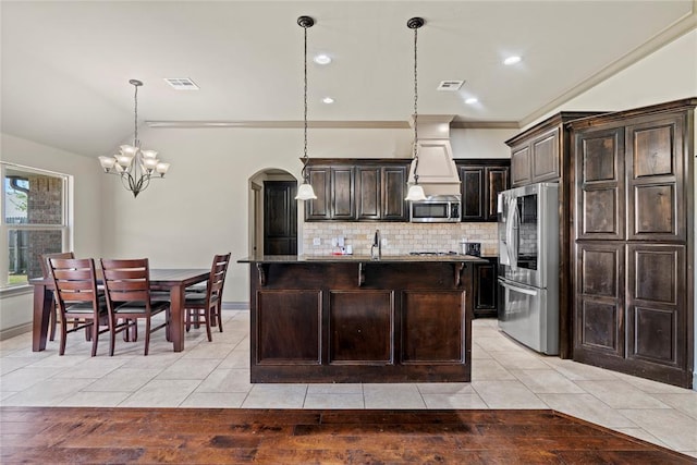 2828 Ryder Dr, Yukon, OK 73099 - kitchen featuring light tile patterned floors, appliances with stainless steel finishes, decorative backsplash, and a notable chandelier