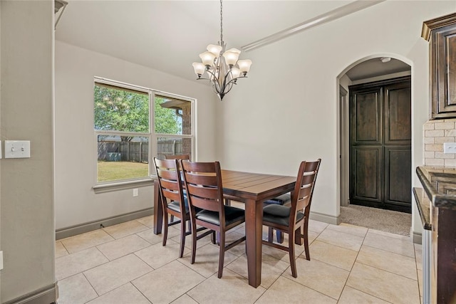 2828 Ryder Dr, Yukon, OK 73099 - dining room featuring arched walkways, baseboards, a chandelier, and light tile patterned flooring