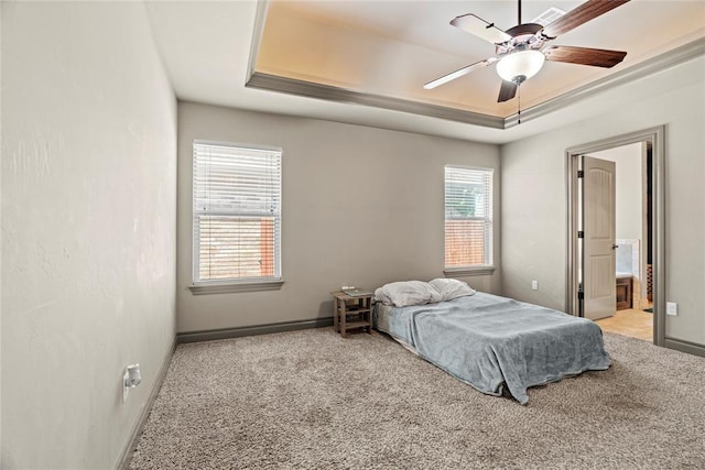 2828 Ryder Dr, Yukon, OK 73099 - carpeted bedroom with baseboards, a raised ceiling, ceiling fan, and ensuite bath