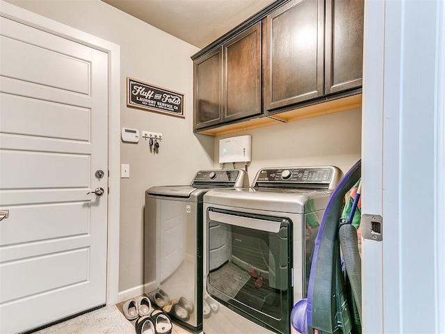 laundry area featuring baseboards, washing machine and dryer, and cabinet space