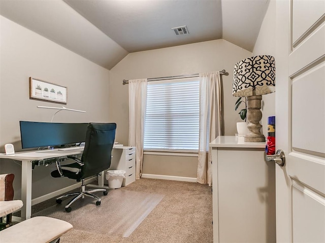 office space featuring visible vents, baseboards, lofted ceiling, and light colored carpet