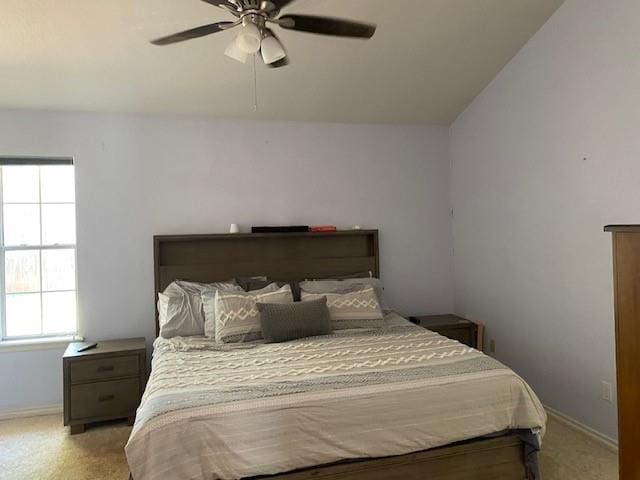 carpeted bedroom featuring baseboards and a ceiling fan
