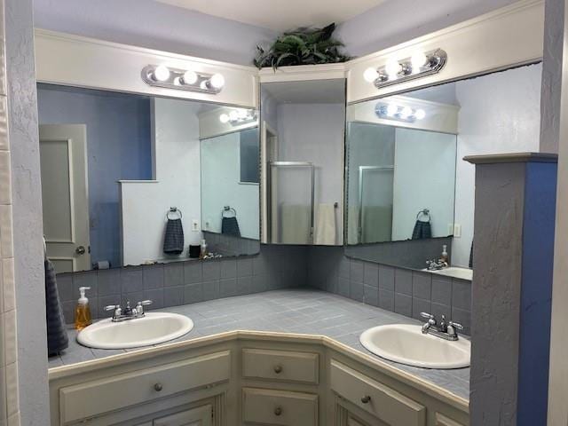 bathroom with decorative backsplash, a sink, and double vanity