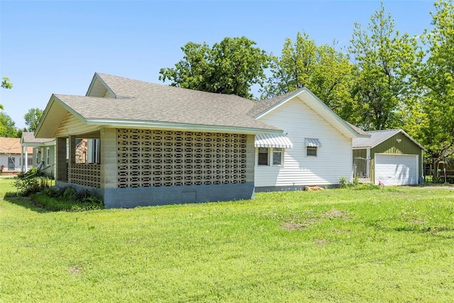724 Maple St, Perry, OK 73077 - view of side of property with roof with shingles, an outbuilding, an attached garage, and a yard