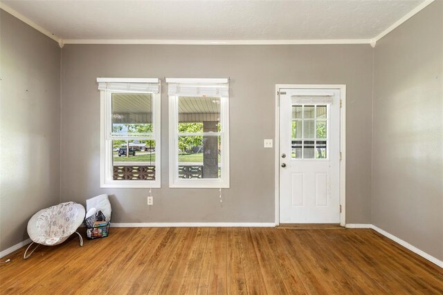 724 Maple St, Perry, OK 73077 - foyer entrance with crown molding, baseboards, a wealth of natural light, and wood finished floors