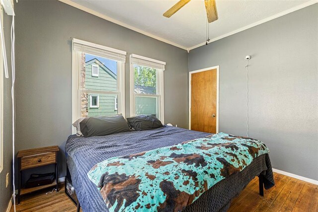 724 Maple St, Perry, OK 73077 - bedroom with crown molding, baseboards, wood-type flooring, and a ceiling fan