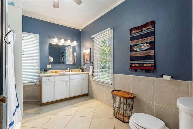 724 Maple St, Perry, OK 73077 - bathroom with toilet, tile walls, ornamental molding, and a wealth of natural light