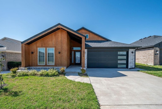 view of front of house with concrete driveway, an attached garage, and a front lawn