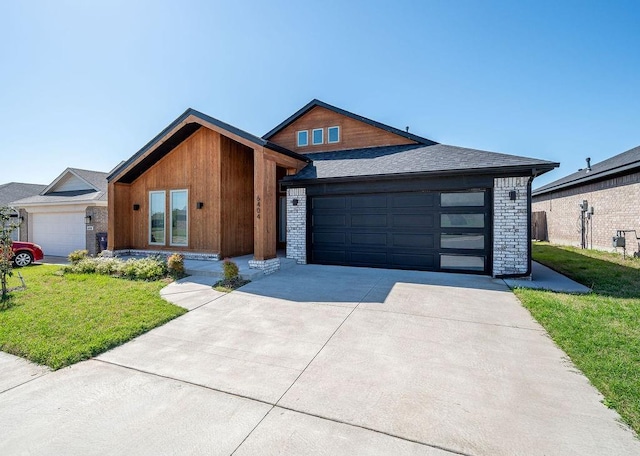 view of front of house with a garage, a front lawn, and concrete driveway
