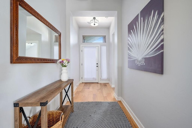 doorway to outside with baseboards and wood finished floors