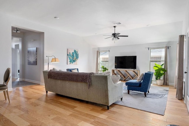 living room featuring ceiling fan, lofted ceiling, a healthy amount of sunlight, and light wood-style floors