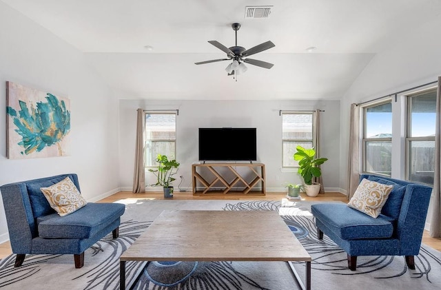living room with lofted ceiling, visible vents, baseboards, and light wood-type flooring