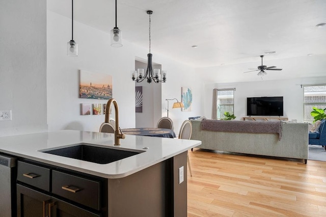 kitchen with plenty of natural light, light wood-style flooring, light countertops, and a sink