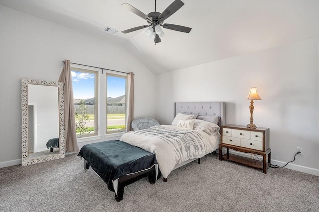 carpeted bedroom featuring vaulted ceiling, visible vents, a ceiling fan, and baseboards