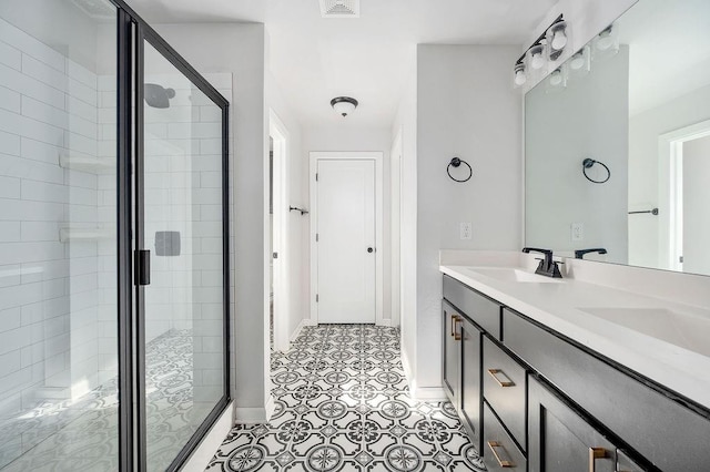 bathroom featuring a shower stall, baseboards, a sink, and double vanity