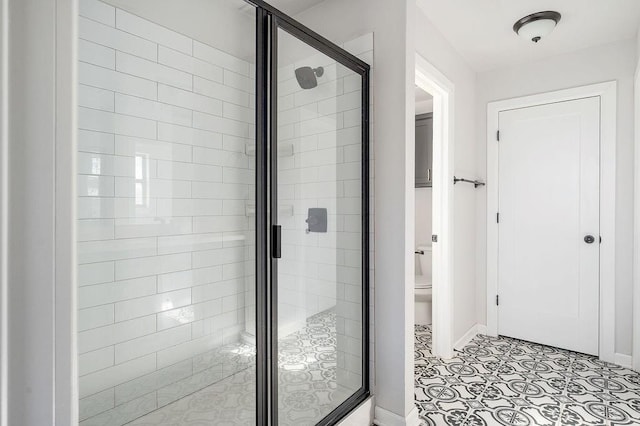 full bathroom with a shower stall, toilet, and baseboards