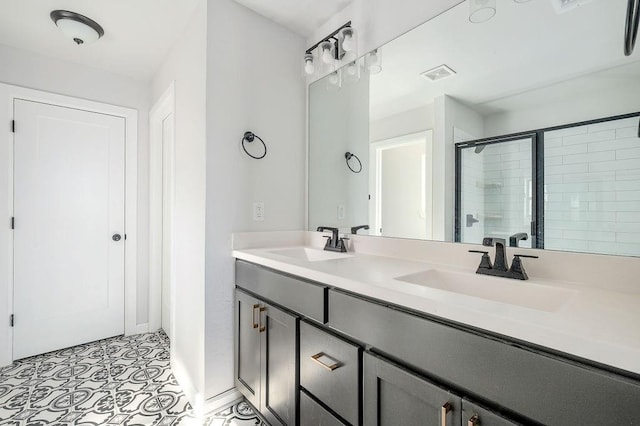 full bath with visible vents, a sink, a shower stall, and double vanity
