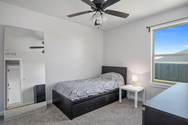 carpeted bedroom with baseboards, a ceiling fan, and visible vents