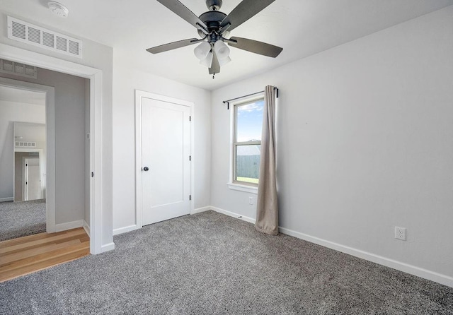 unfurnished bedroom featuring visible vents, carpet flooring, baseboards, and a ceiling fan