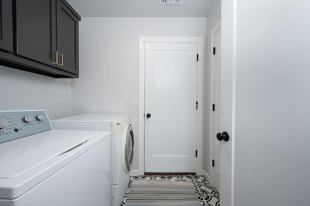 clothes washing area featuring separate washer and dryer, cabinet space, and visible vents