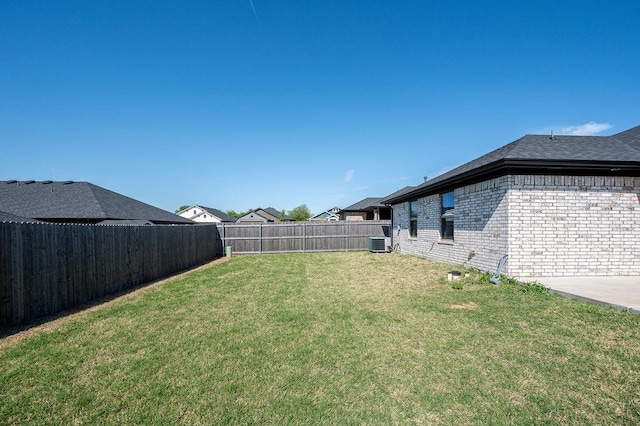 view of yard featuring central AC and a fenced backyard