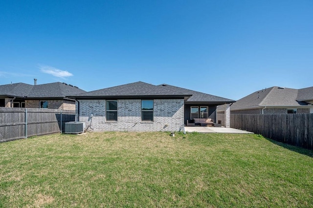 back of property with a lawn, a fenced backyard, brick siding, and a patio