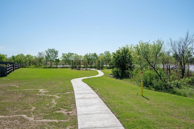 view of home's community featuring fence and a lawn