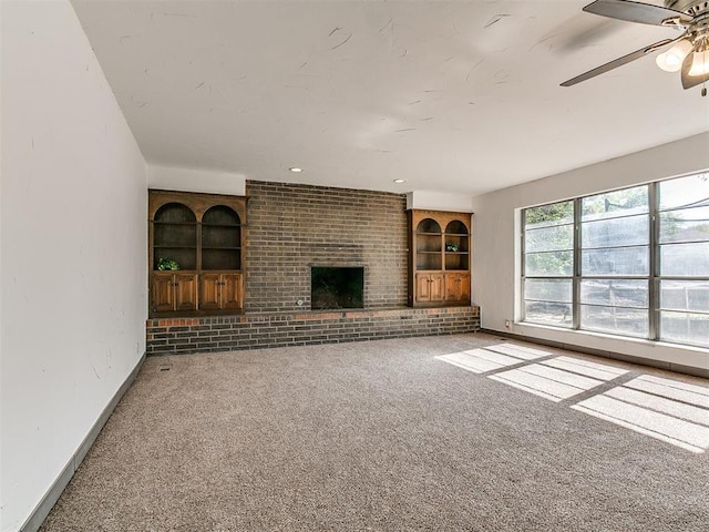 11609 Windmill Rd, Oklahoma City, OK 73162 - unfurnished living room featuring carpet, ceiling fan, built in features, a fireplace, and baseboards