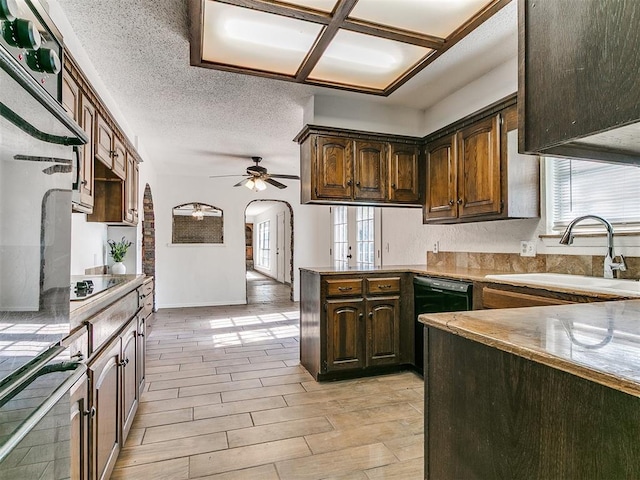 11609 Windmill Rd, Oklahoma City, OK 73162 - kitchen with a sink, arched walkways, a wealth of natural light, black appliances, and a peninsula