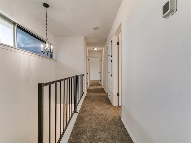 11609 Windmill Rd, Oklahoma City, OK 73162 - corridor with a textured ceiling, carpet, and a chandelier
