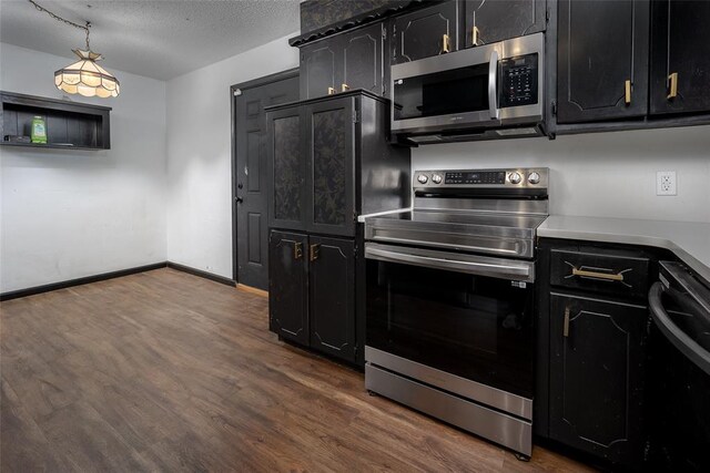 1906 NW 66th Cir, Lawton, OK 73505 - kitchen featuring dark cabinets, a textured ceiling, dark wood finished floors, stainless steel appliances, and baseboards