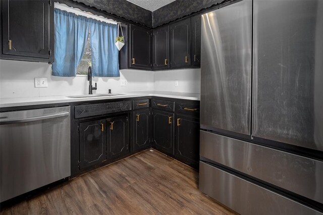 1906 NW 66th Cir, Lawton, OK 73505 - kitchen featuring dark wood-type flooring, light countertops, dark cabinets, a sink, and appliances with stainless steel finishes
