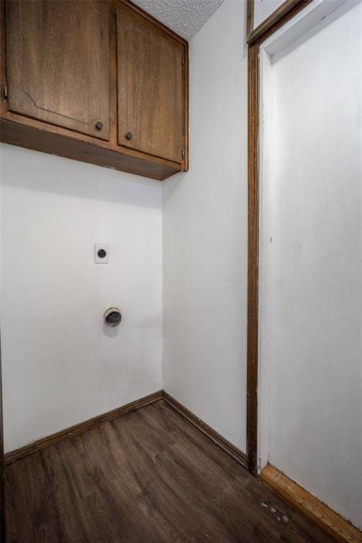 1906 NW 66th Cir, Lawton, OK 73505 - laundry area with baseboards, dark wood-type flooring, a textured ceiling, electric dryer hookup, and cabinet space