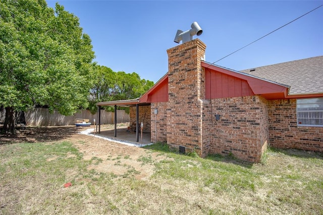 1906 NW 66th Cir, Lawton, OK 73505 - exterior space featuring a lawn, fence, a chimney, and roof with shingles