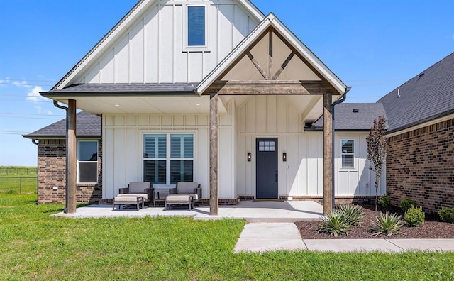 4162 Hawthorne St NW, Piedmont, OK 73078 - view of front of home featuring board and batten siding, a front yard, roof with shingles, and brick siding
