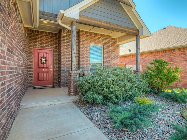 doorway to property featuring board and batten siding and brick siding