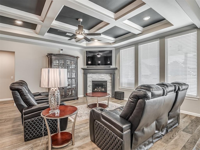 living area featuring a fireplace, baseboards, ceiling fan, and coffered ceiling