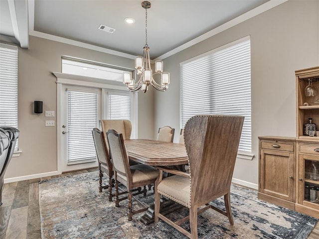 dining room featuring visible vents, crown molding, baseboards, and an inviting chandelier